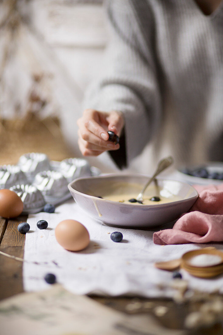 Young woman making blueberry mini bundt cakes