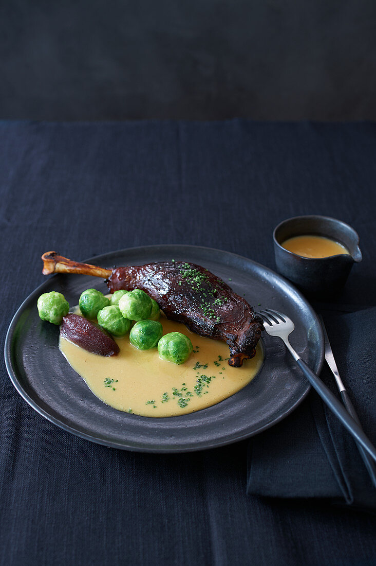 Glazed goose leg with apple compote and Brussels sprouts