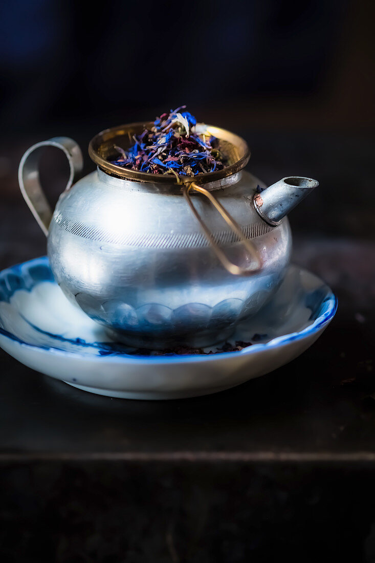 Tea kettle with a tea strainer and tea leaves