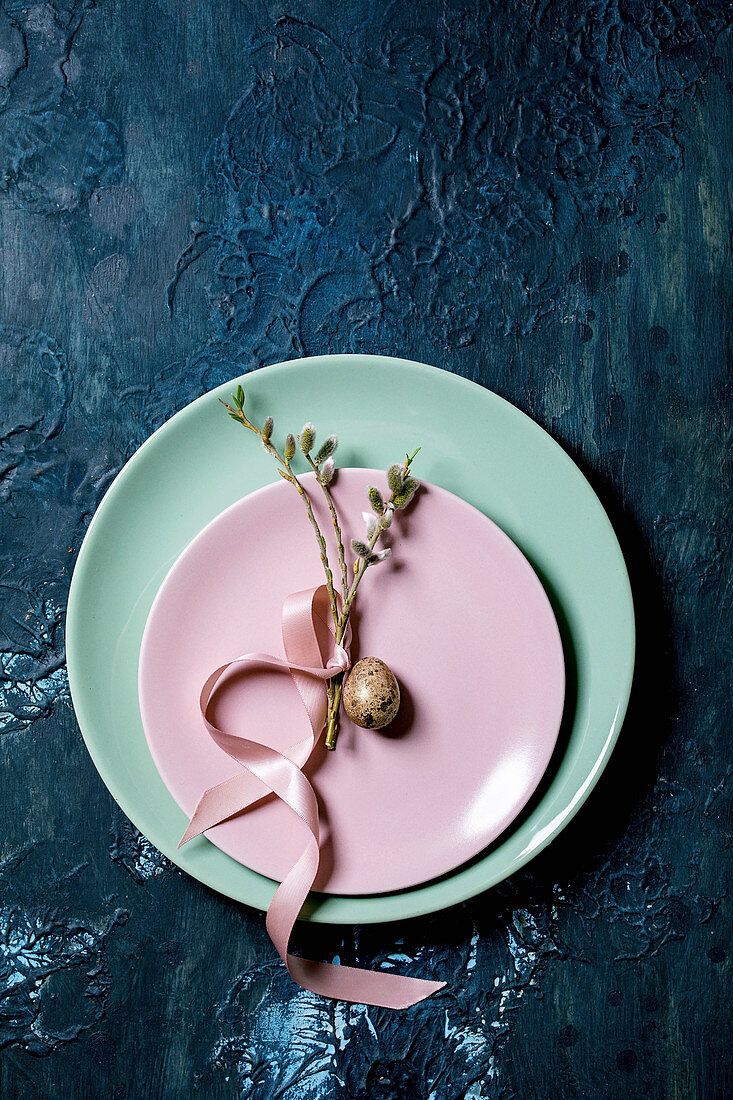 Österliches Tischgedeck in Pastelltönen mit Weidenzweigen und Wachtelei