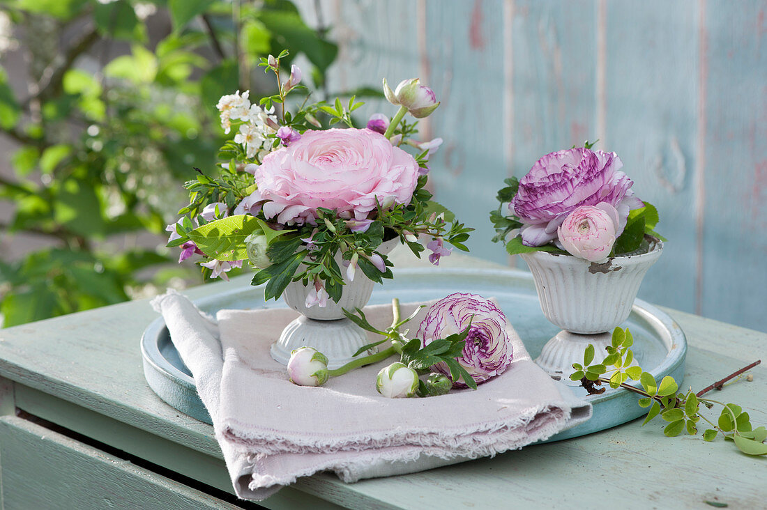 Small Easter decorations with ranunculus, rose broom and orange flower, Easter eggs as decoration