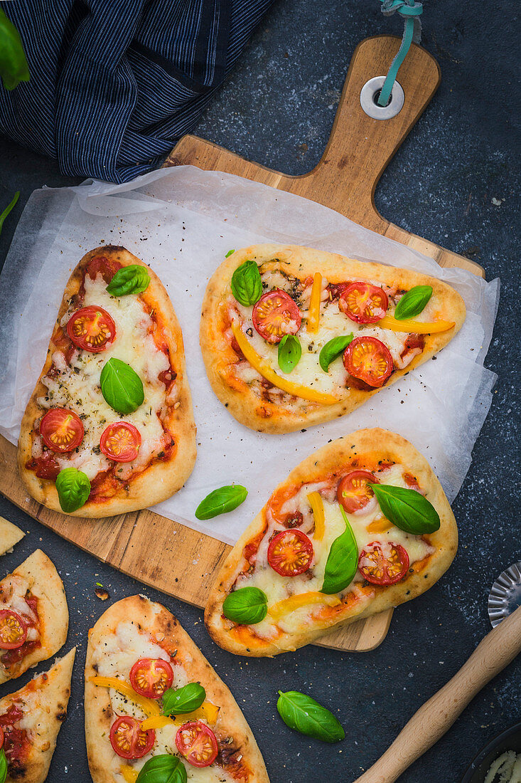 Flatbread Pizza made with Naan bread, tomato sauce, mozzarella cheese, tomato and basil