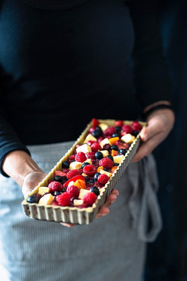 Berry Tart being held by a cook