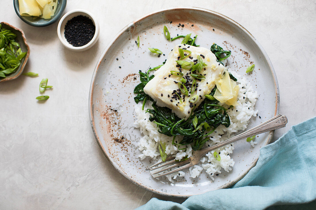 Baked white fish fillet, wilted spinach and green beans on a bed of rice.