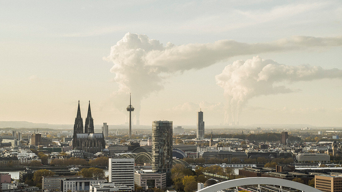 Blick auf Köln, im Hintergrund Rauch steigt aus den Fabriken auf