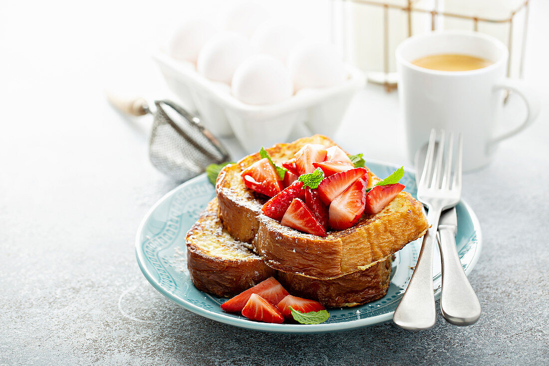 Spiked strawberry french toasts with powdered sugar