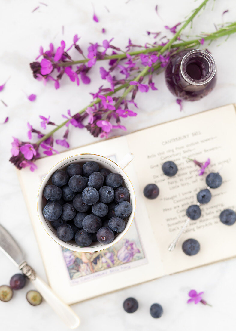 Blueberries alongside purple flowers