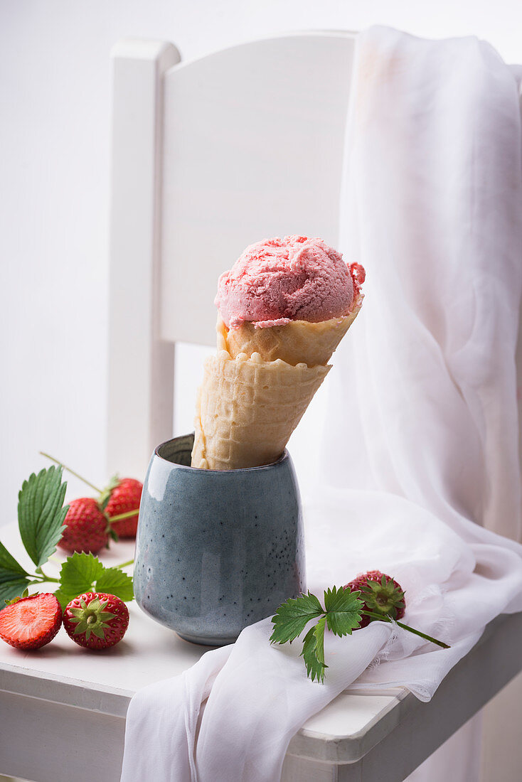 Vegan strawberry ice cream in a waffle cone