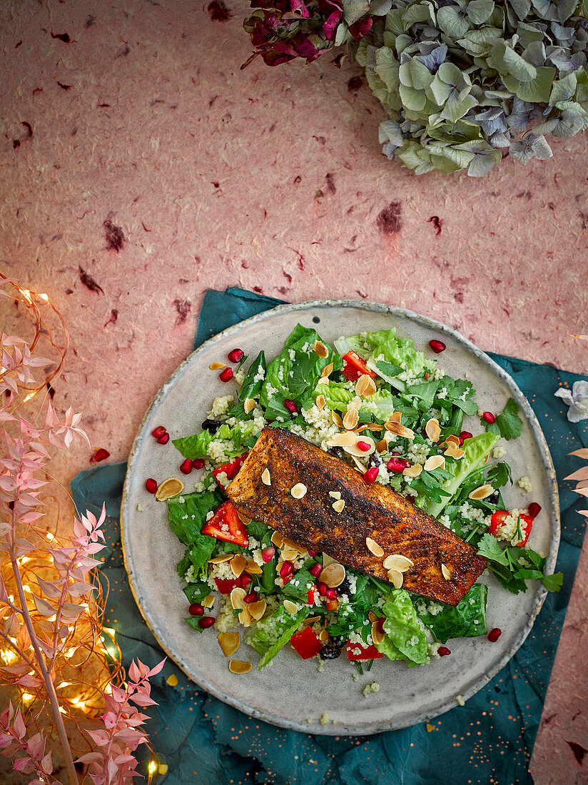 Ras el hanout salmon on vegetable couscous with pomegranate seeds