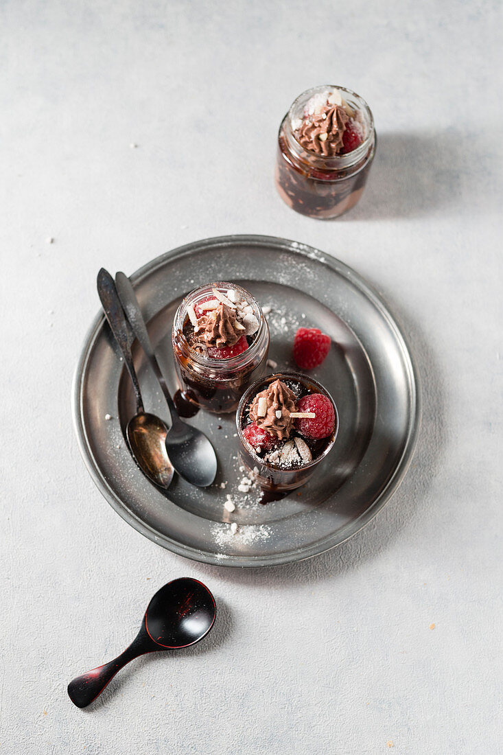 Schichtdessert mit Schokocreme, Gebäck, Baiser und Himbeeren