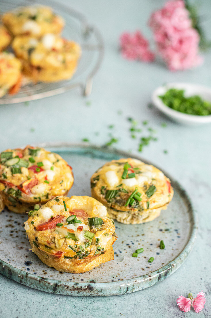 Egg muffins with asparagus, cherry tomatoes halloumi cheese and chives