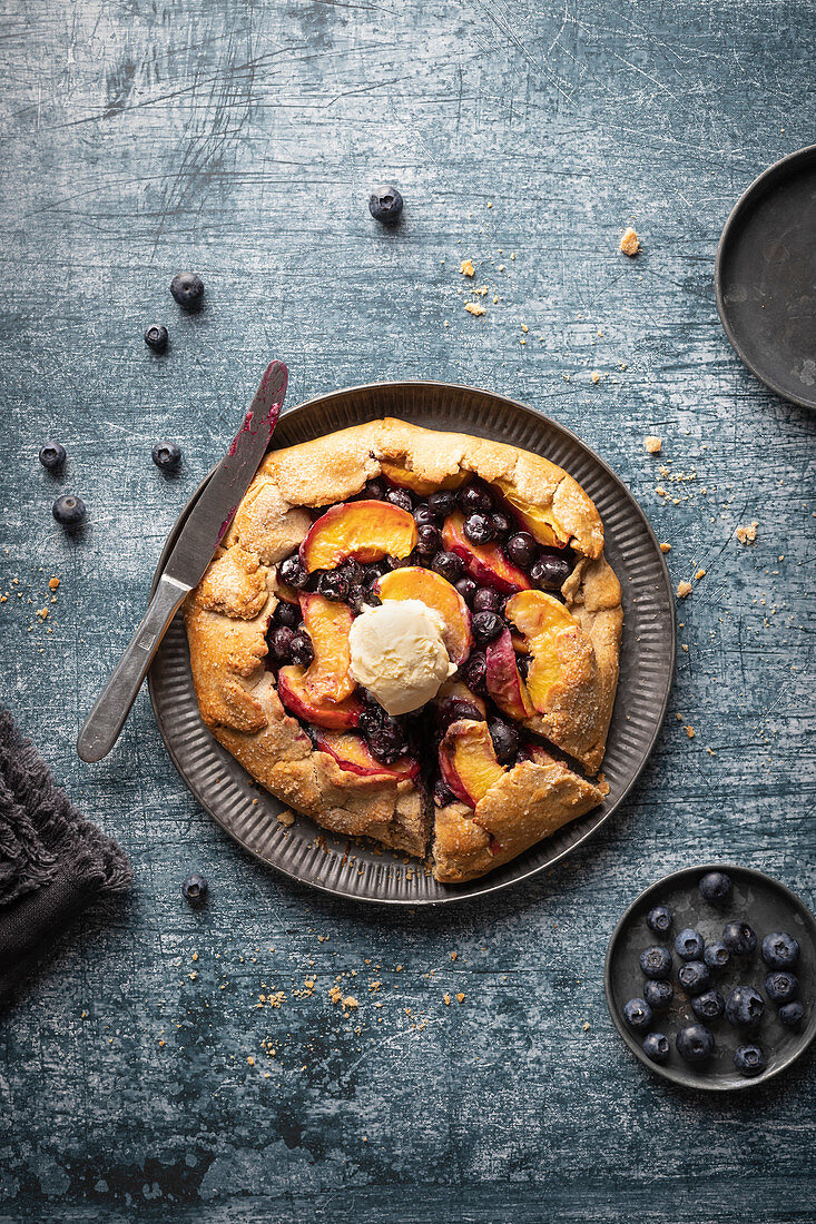 Rustic tart (gallette) with peaches and blueberries, served with vanila ice cream