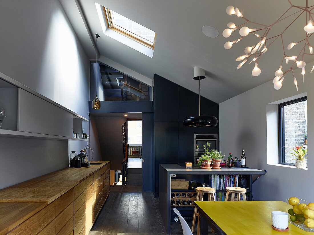 Open-plan kitchen, dining table and high ceiling in modern interior