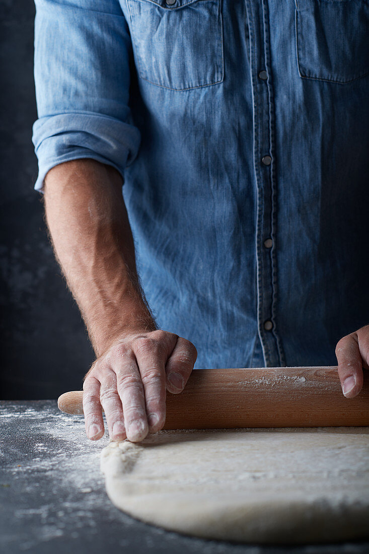 A man rolling out dough