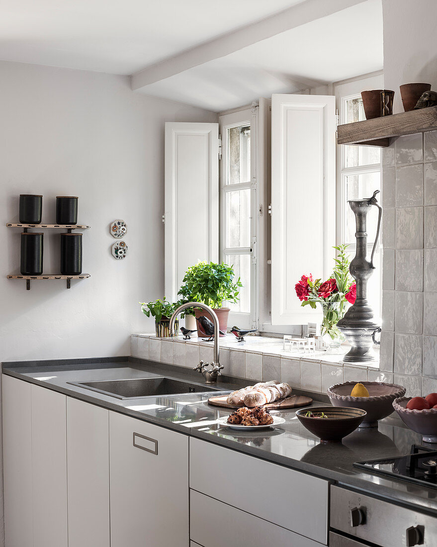 Antique ornaments on windowsill of modern kitchen