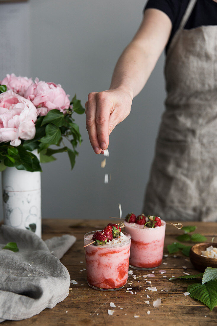 Erdbeercremedessert mit weißen Schokoraspeln bestreuen