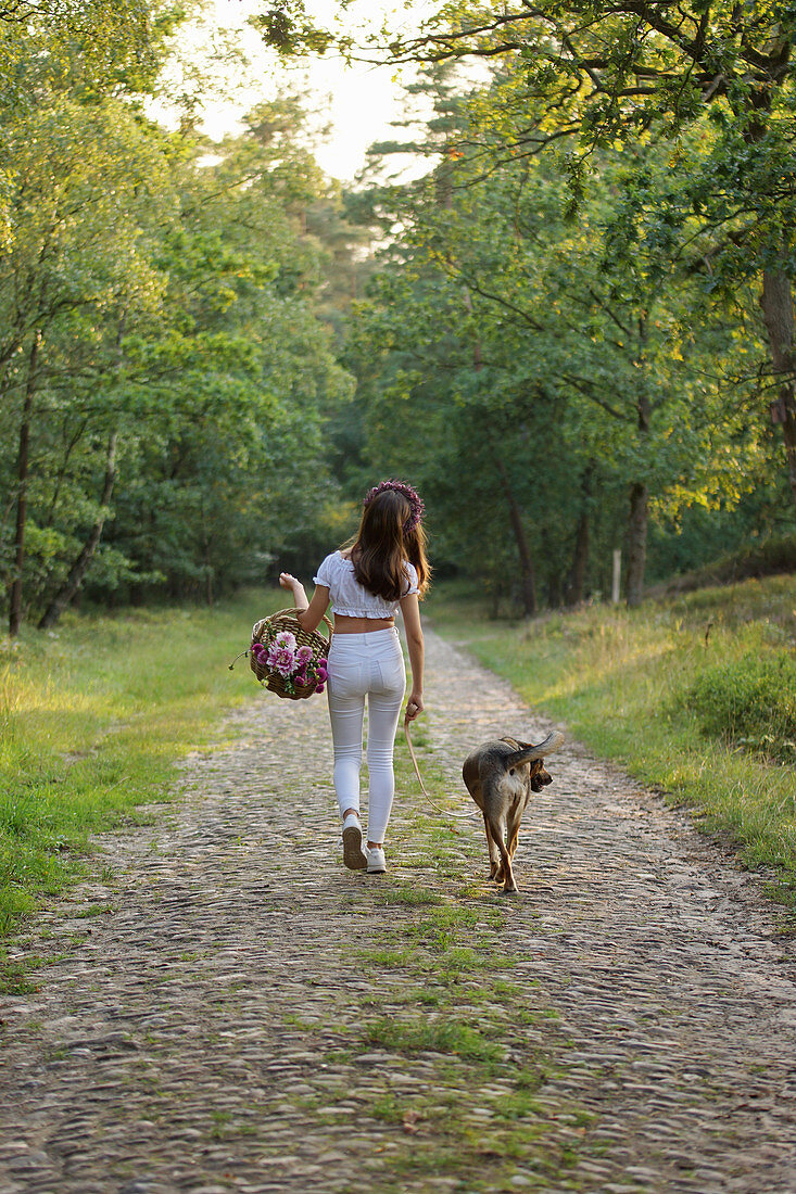 Woman walking with dog in woods