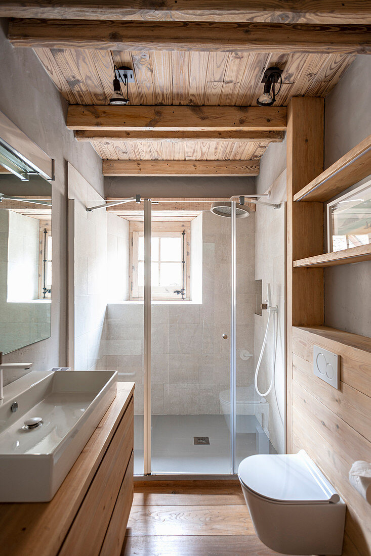 Bathroom with wooden furnishings, designer sink and shower area