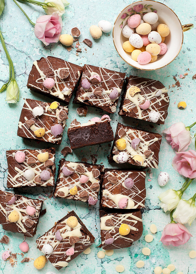Chocolate brownies for Easter decorated with white chocolate and pastel coloured mini eggs