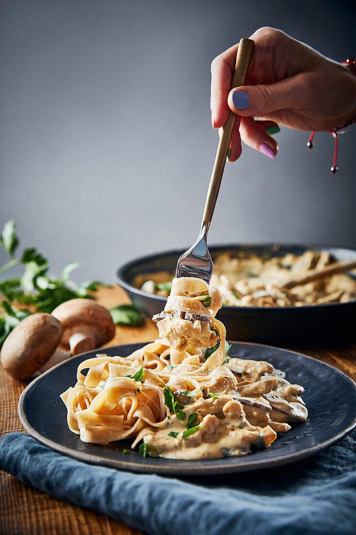 Vegan tagliatelle with a plant-based meat substitute and a creamy mushroom sauce