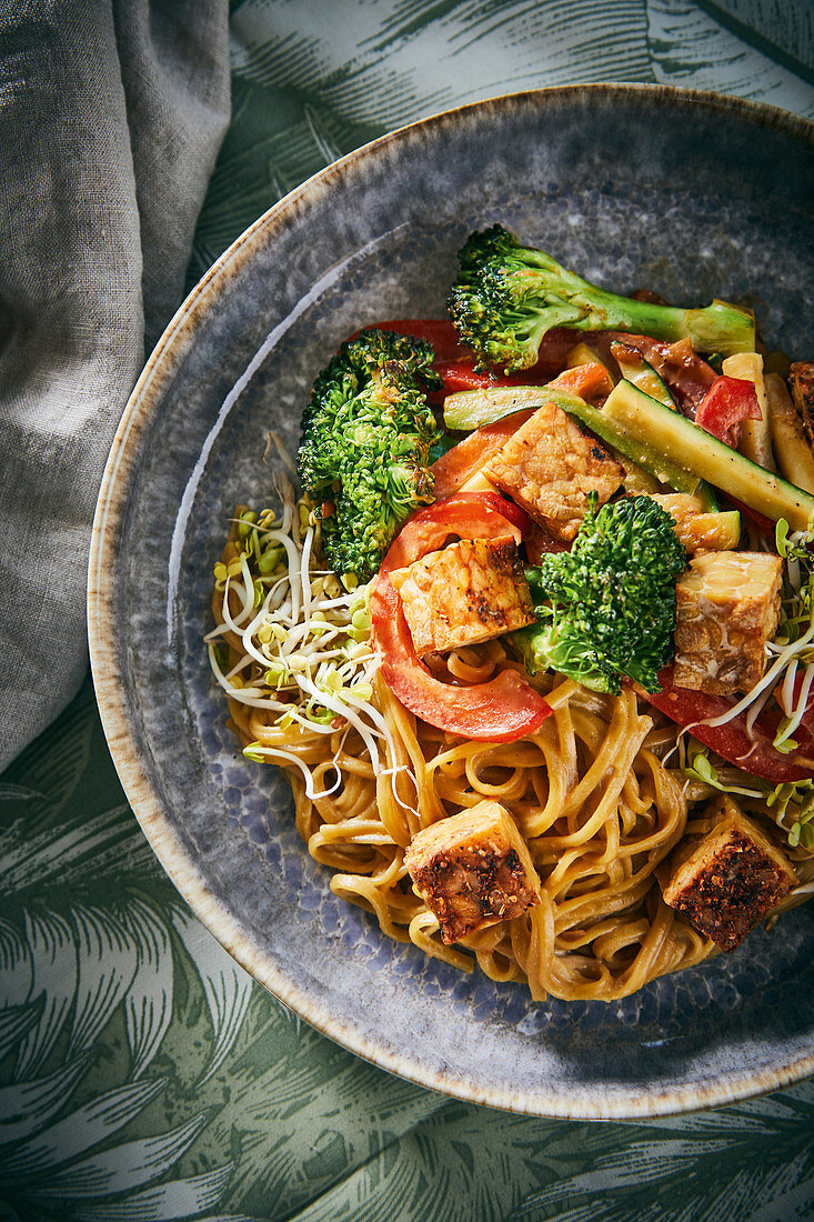 Fried vegetables with soba noodles, tempeh and a peanut and chilli sauce (vegan)