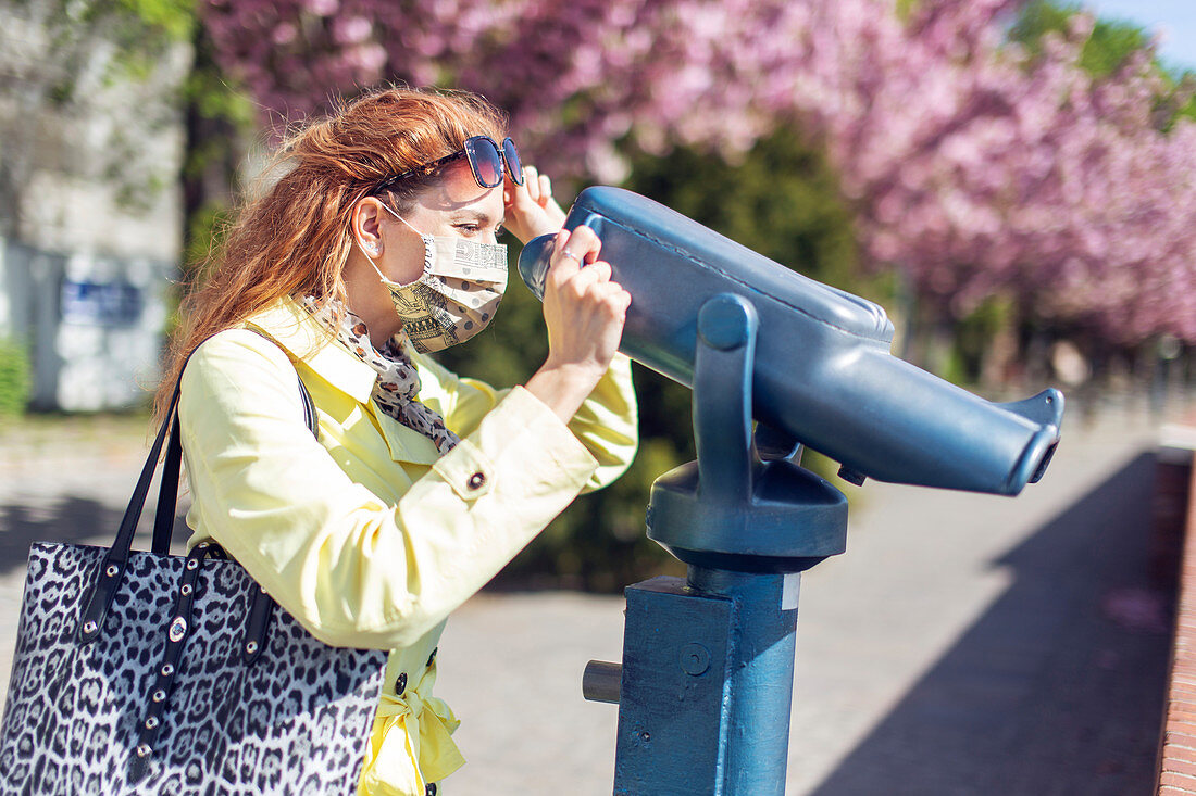Woman using coin-operated binoculars