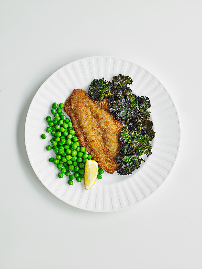 Fish schnitzel with kale chips and peas