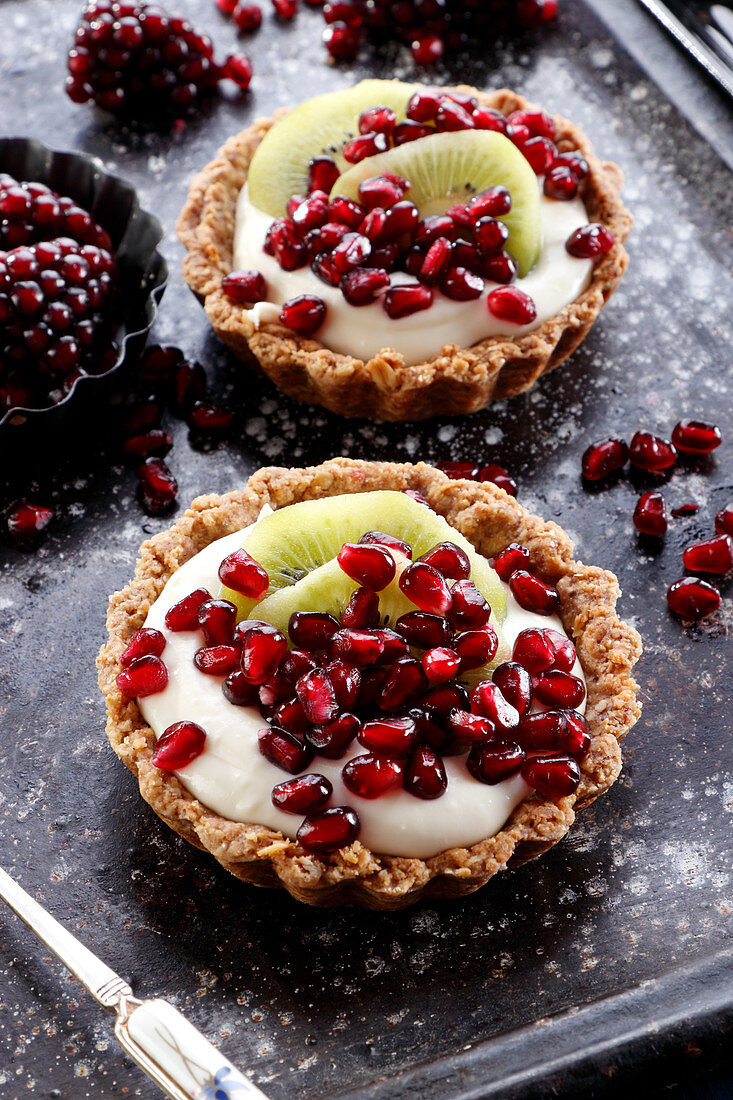 Tartlets with pudding cream and pomegranates