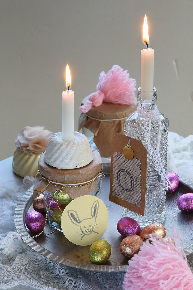 Vintage arrangement of candles and chocolate Easter eggs on table