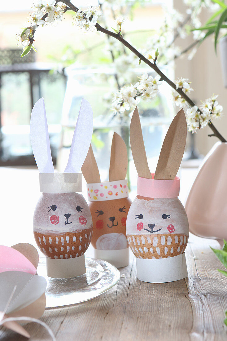 Easter eggs with painted faces and paper bunny ears