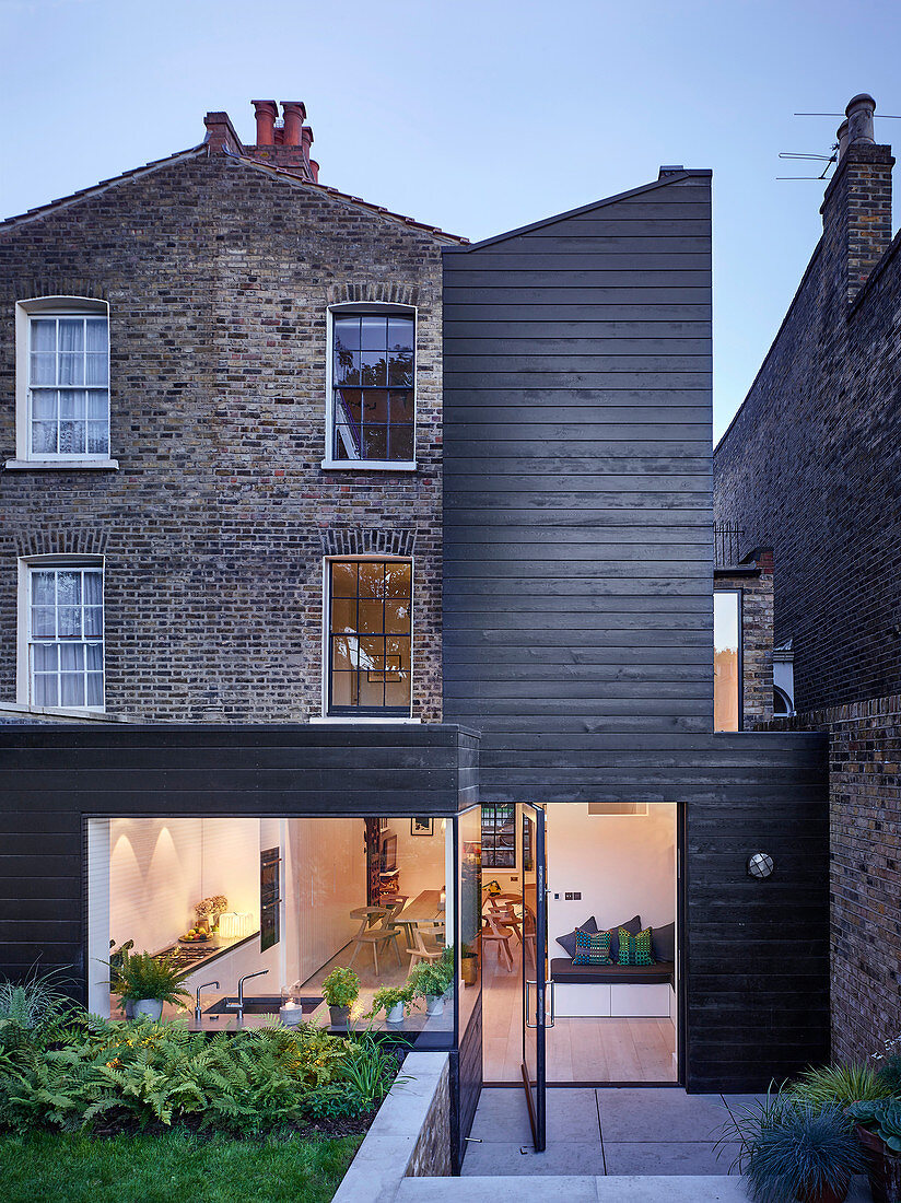 Brick house with modern wood-clad extension and swivelling terrace doors