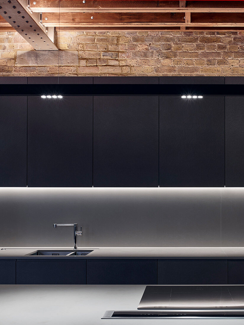 Modern monochrome kitchen with island counter in restored brick house