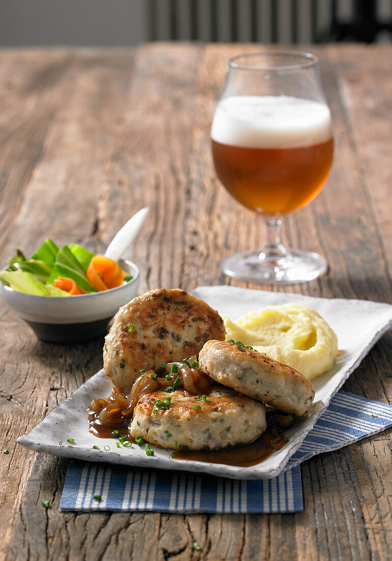 Cod cakes with an onion and beer sauce and mashed potatoes