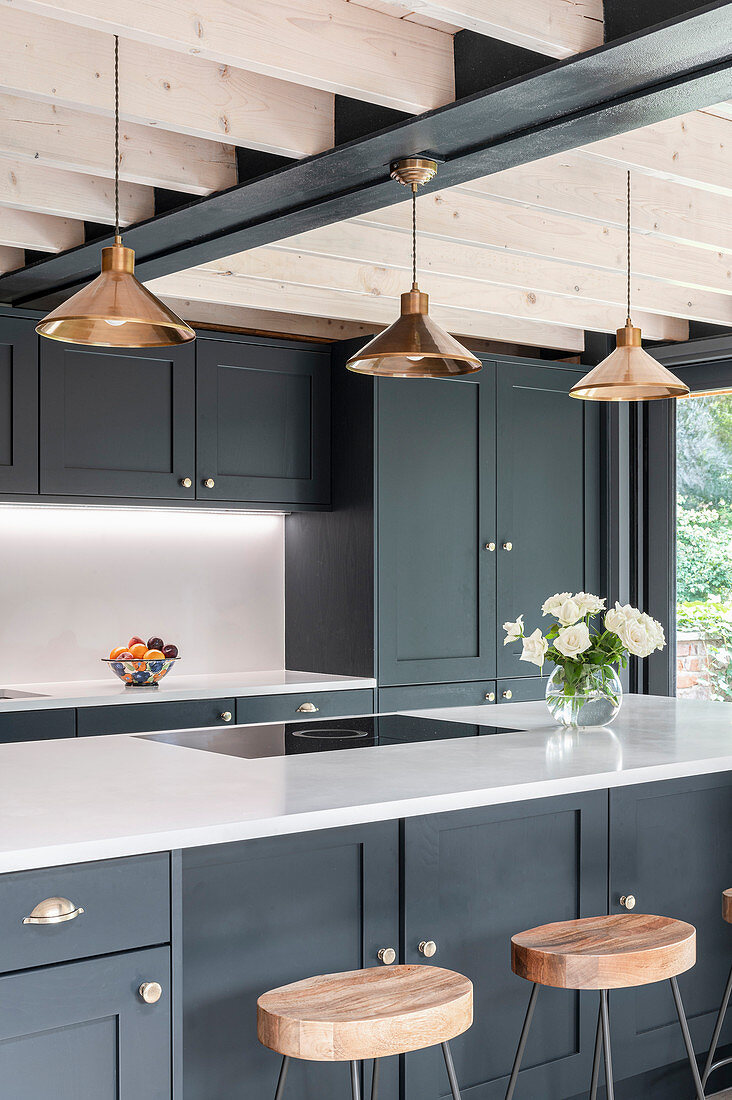 Barstools at counter in modern kitchen with grey cabinets