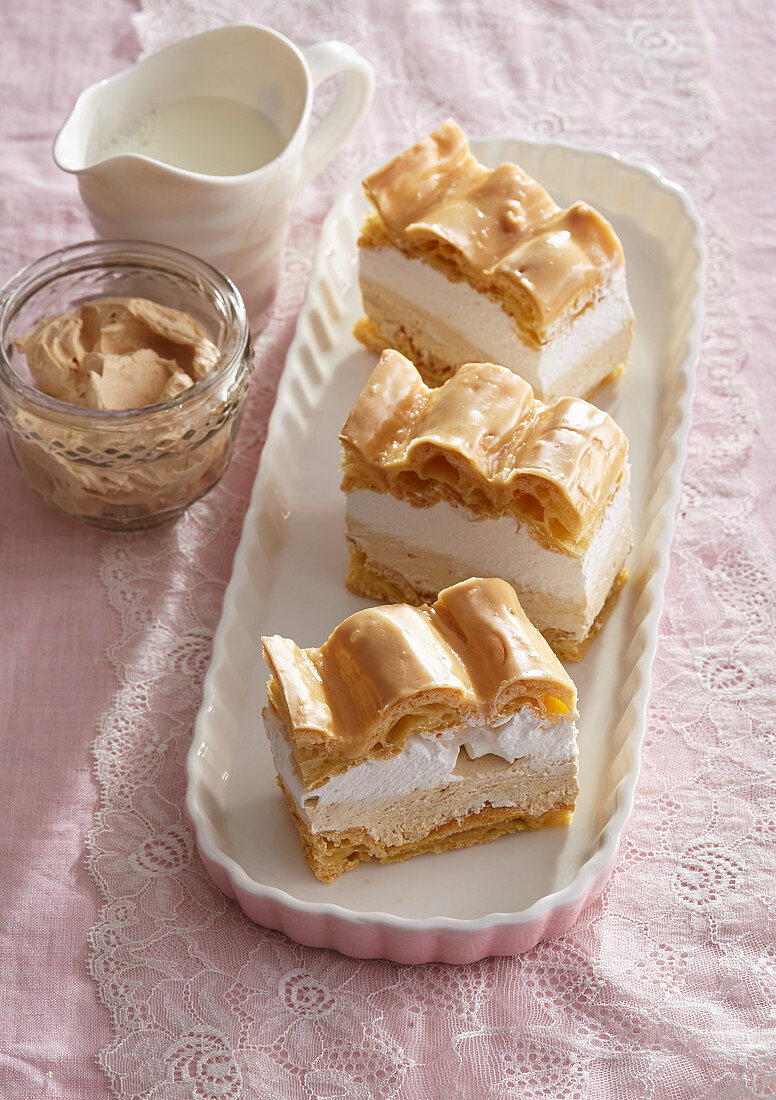 Choux pastry slices from the tray with whipped cream and caramel cream
