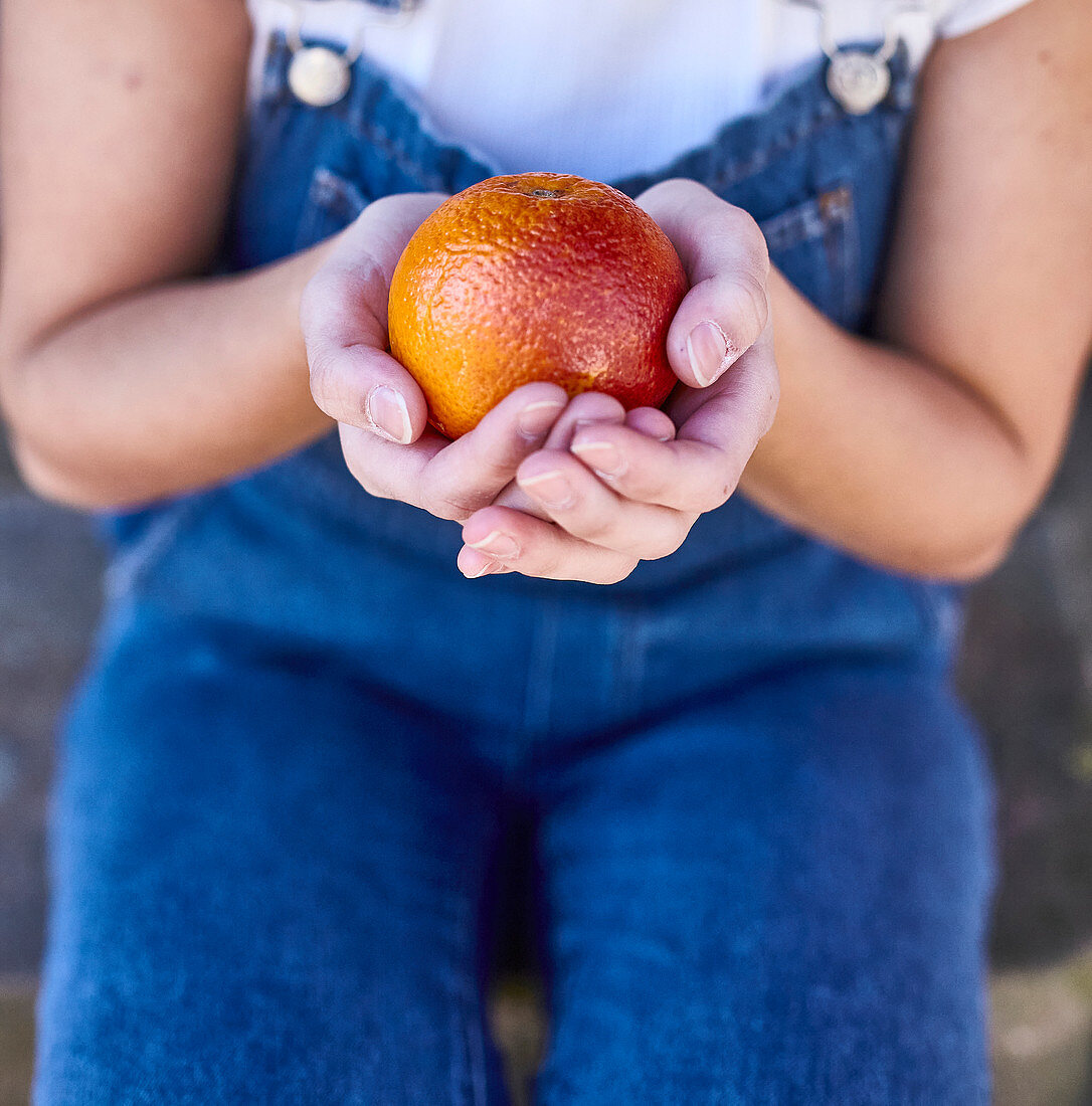 Girl holding a blood orange