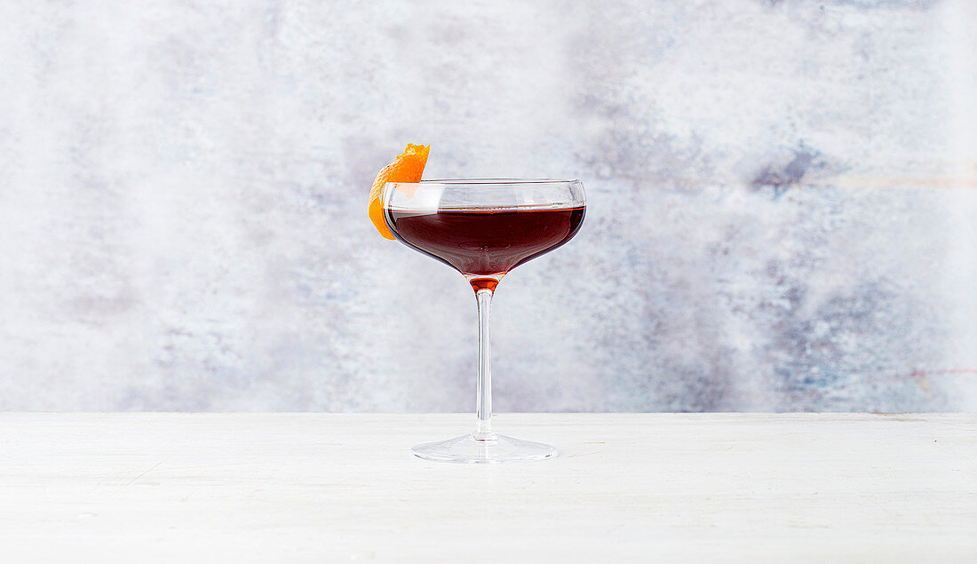Cocktail with red wine and orange peel