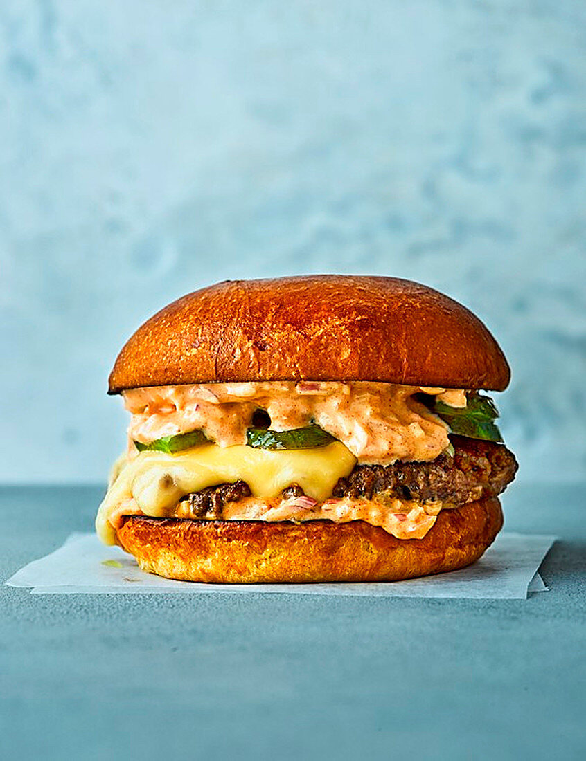 Cheeseburger vor blauem Hintergrund