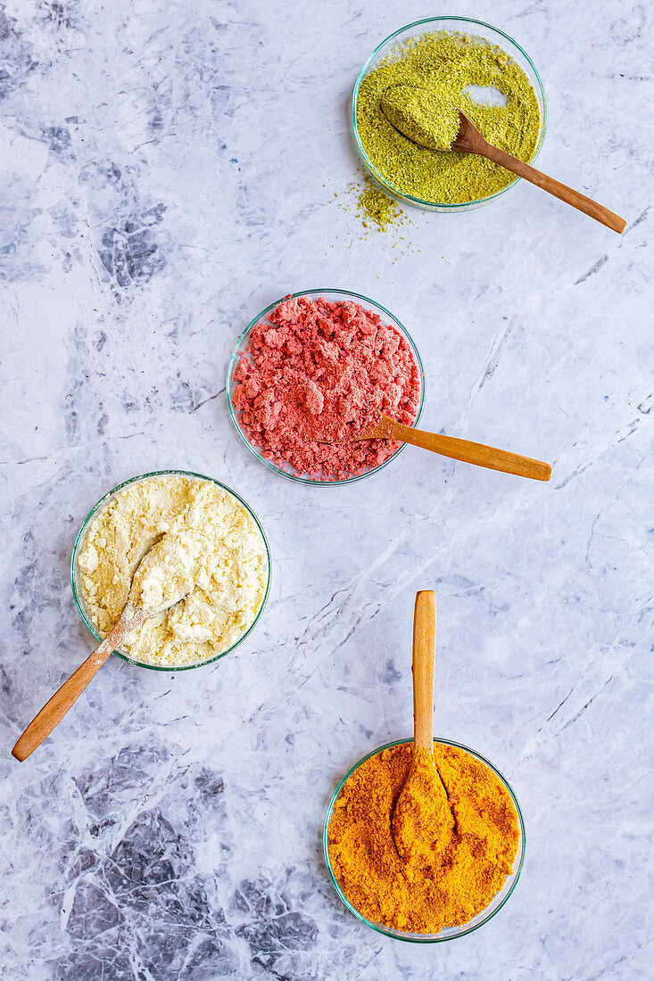 Lime, grapefruit, strawberry and pineapple fruit powder in bowls