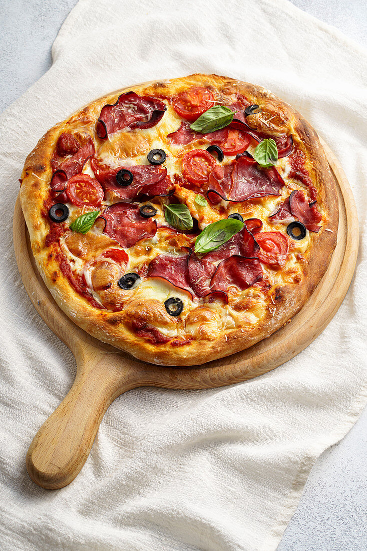 Pizza mit Rohschinken und Oliven