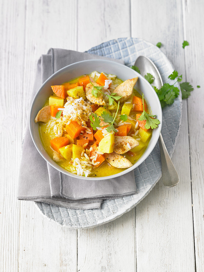 Chicken stew with rice, carrots, potatoes and coriander greens