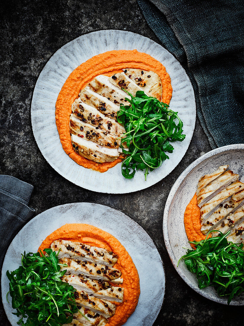 Warm red pepper hummus with coriander chicken breasts