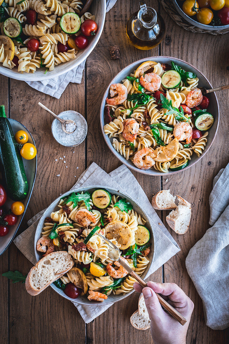 Mediterranean pasta salad with rocket, tomatoes and grilled prawns