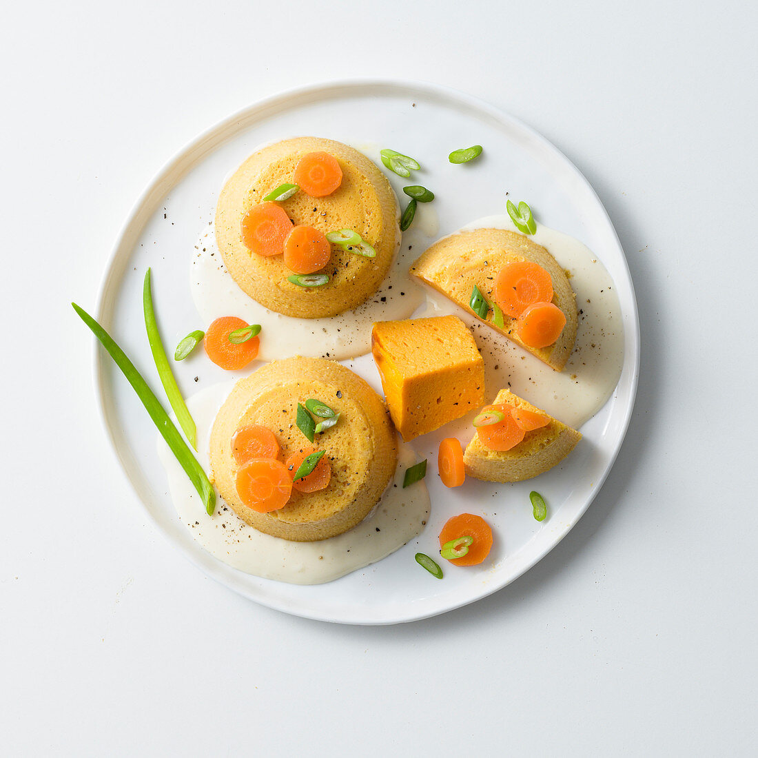 Carrot flans with spring onions and cheese sauce