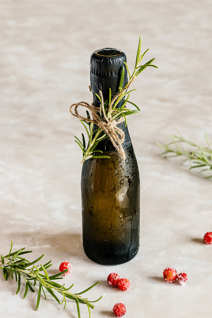 Black mini bottle of champagne decorated with rosemary