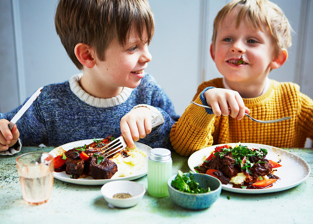 Boys eating slow cooker beef stew