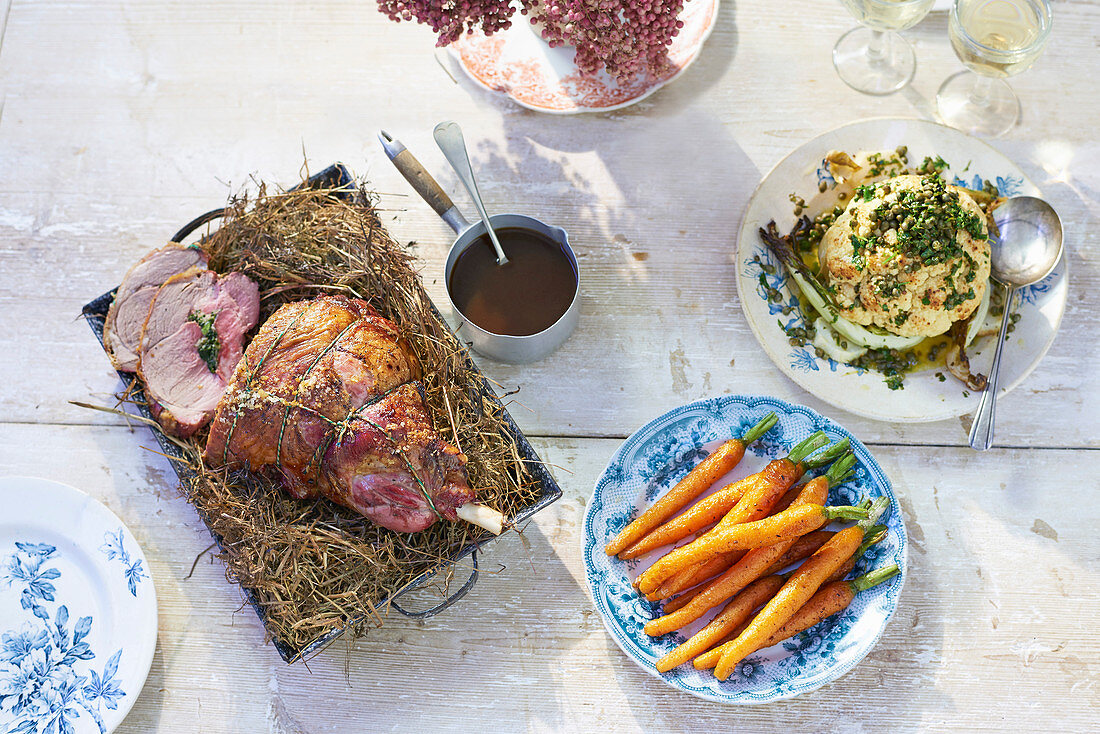 Im Heu gebackene gefüllte Lammkeule, gebratener Blumenkohl mit Kaperndressing und Kümmel-Karotten