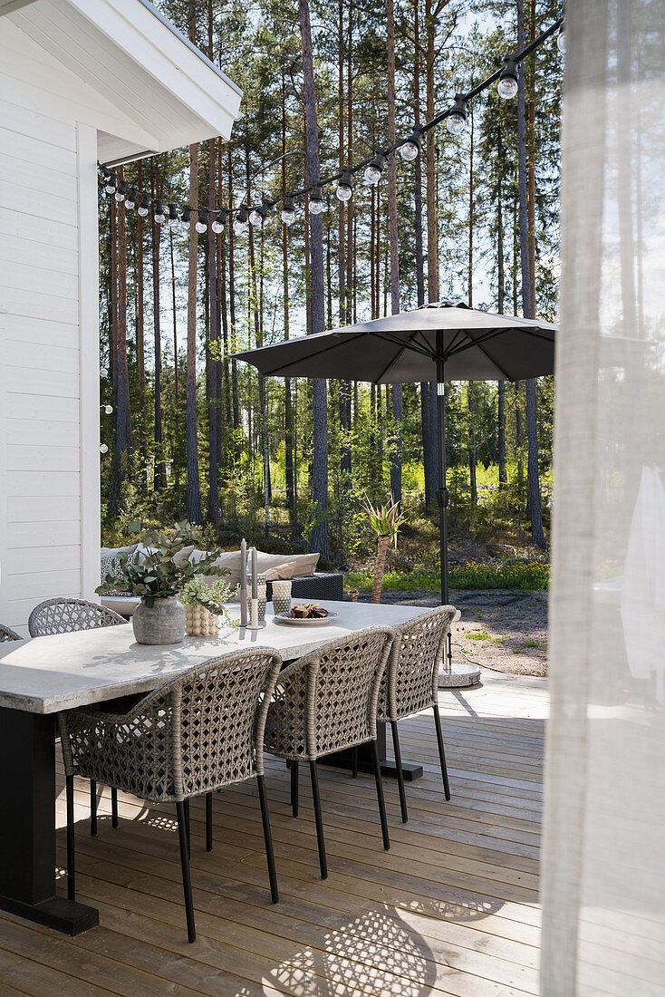 Selbst gebauter Tisch mit Betonplatte und Kunst-Rattanstühle auf der Terrasse