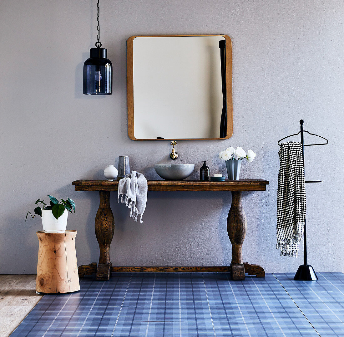 Rustic wooden console with countertop washbasin in a country bathroom