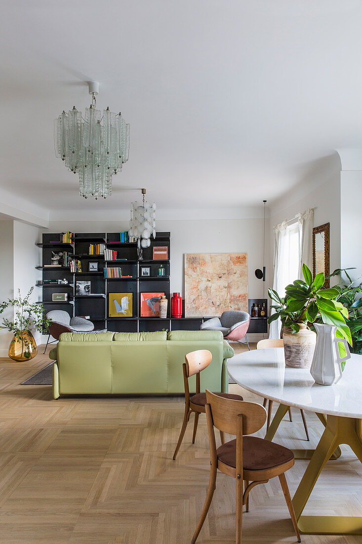 Dining table and sofa in open-plan living room in classic retro style